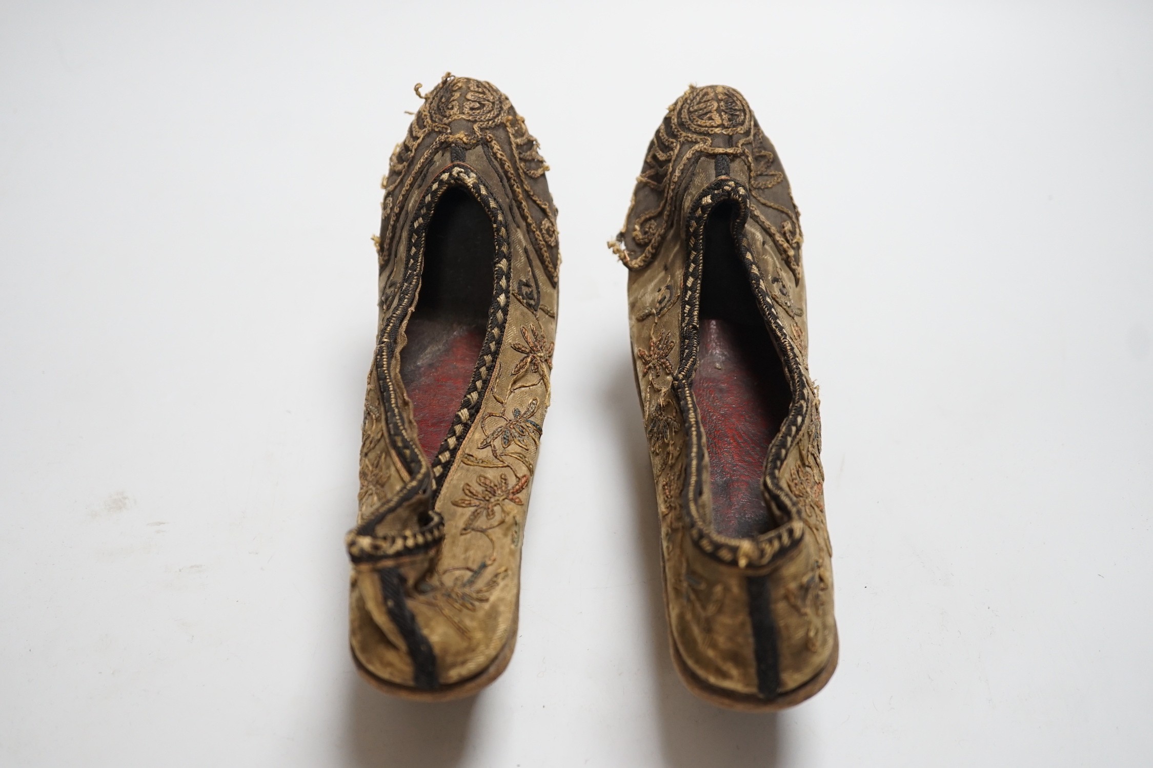 A pair of late 19th century Chinese silk embroidered shoes with Bell inset soles